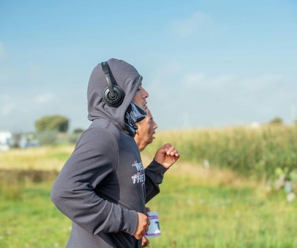 Person smiling while doing light cardio exercises in a bright room.