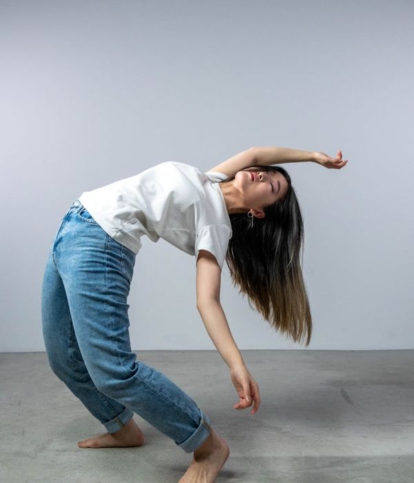 Young woman performing stretching exercises in a minimalist modern studio.